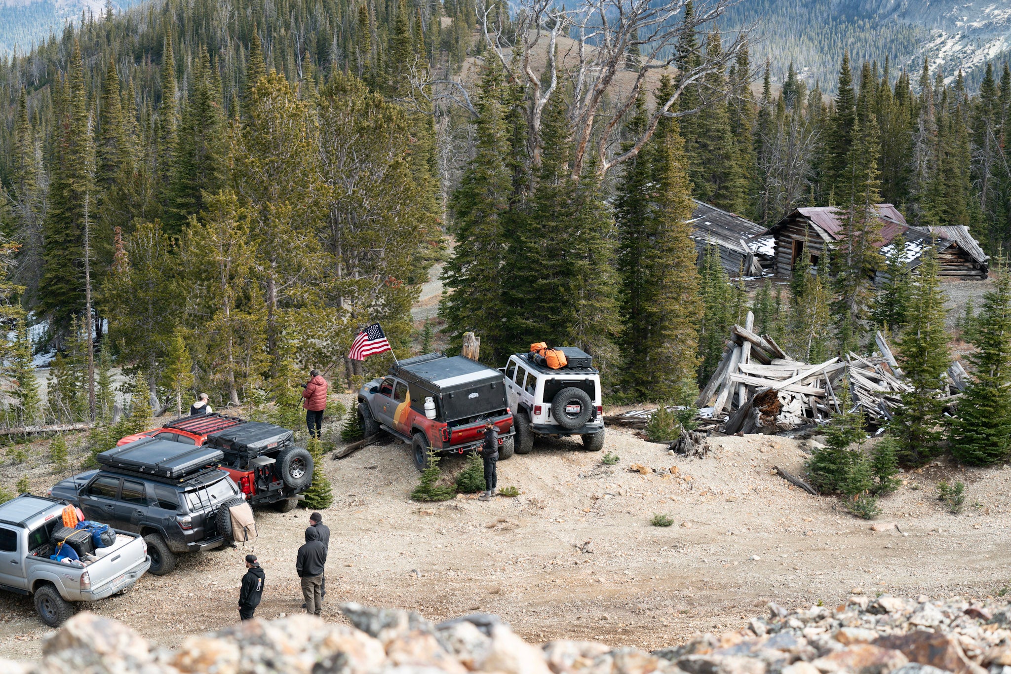 Aerial view of a campsite with five trucks and camping gear