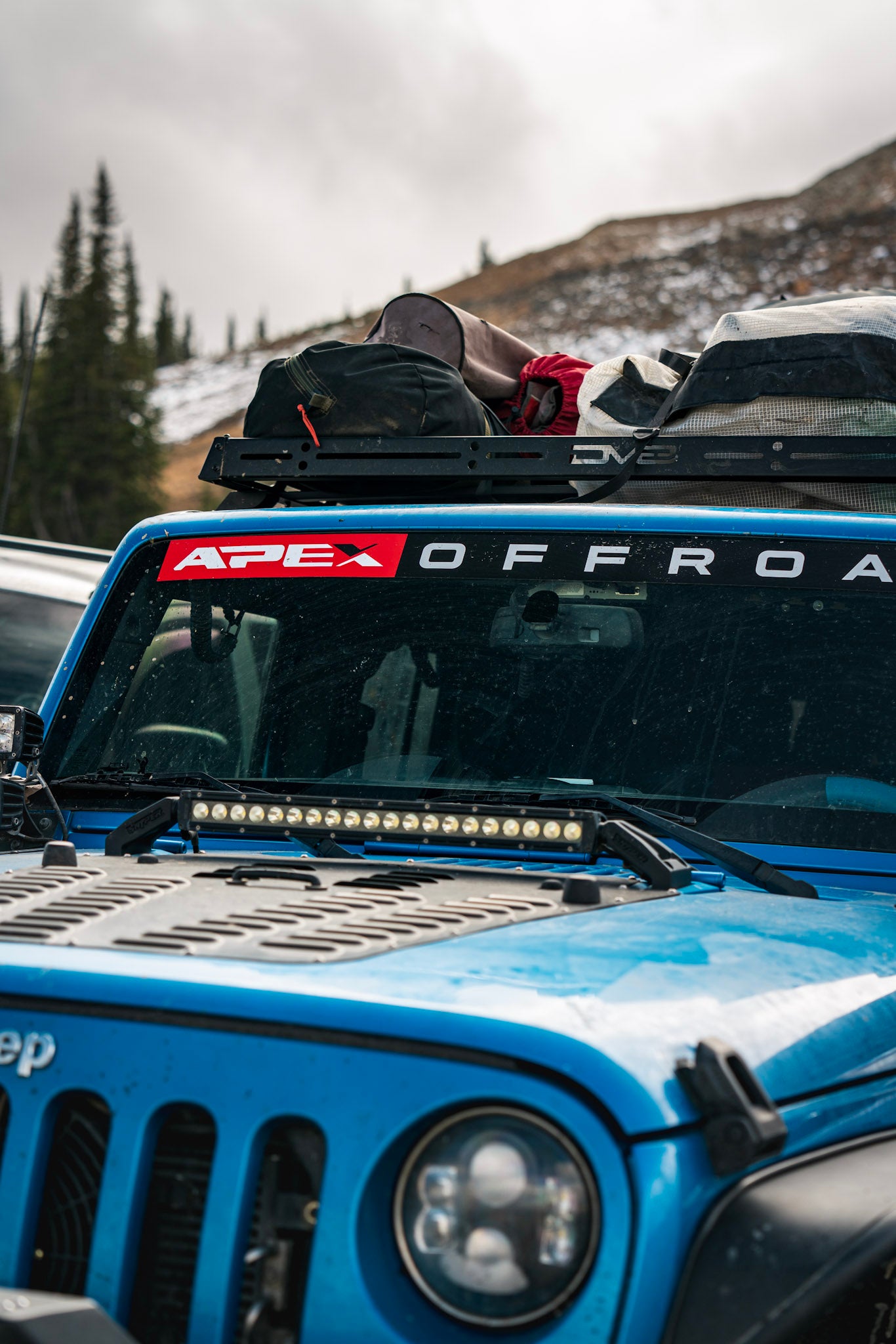 Blue Jeep with "Apex Offroad" decal on windshield
